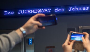 Auf einem Laufband erscheint "Jugendwort des Jahres" über den digitalen Newsticker eines Hotels.