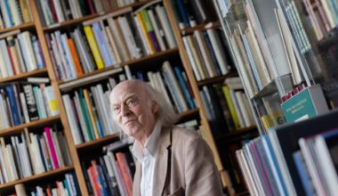 Antiquar Klaus Willbrand steht zwischen Büchern in seinem Antiquariat in Sülz.