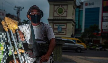 Ein Bewohner einer Leprakolonie sitzt mit einer Beinprothese an einer Kreuzung in Indonesien