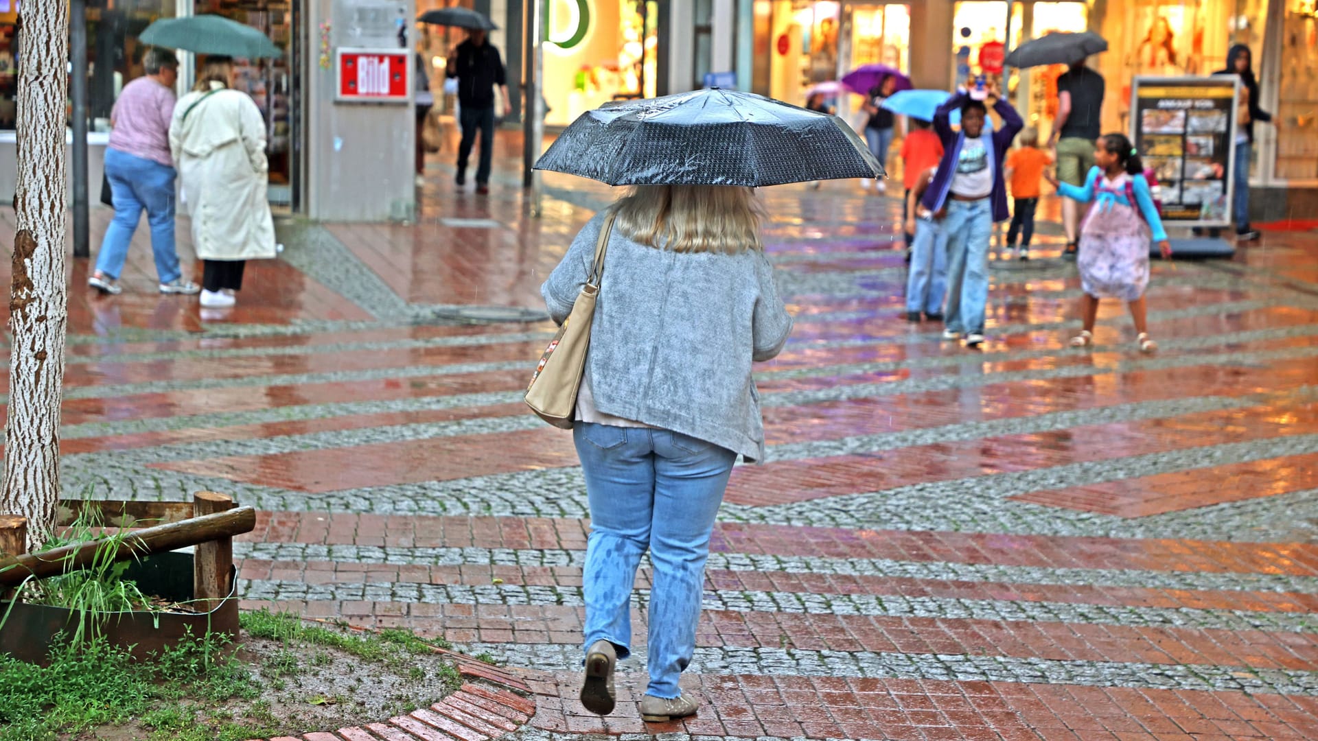 Menschen laufen bei Regen durch Essen (Archivbild): Am Montag und Dienstag sollten die Bewohner von NRW am besten immer einen Schirm zur Hand haben.