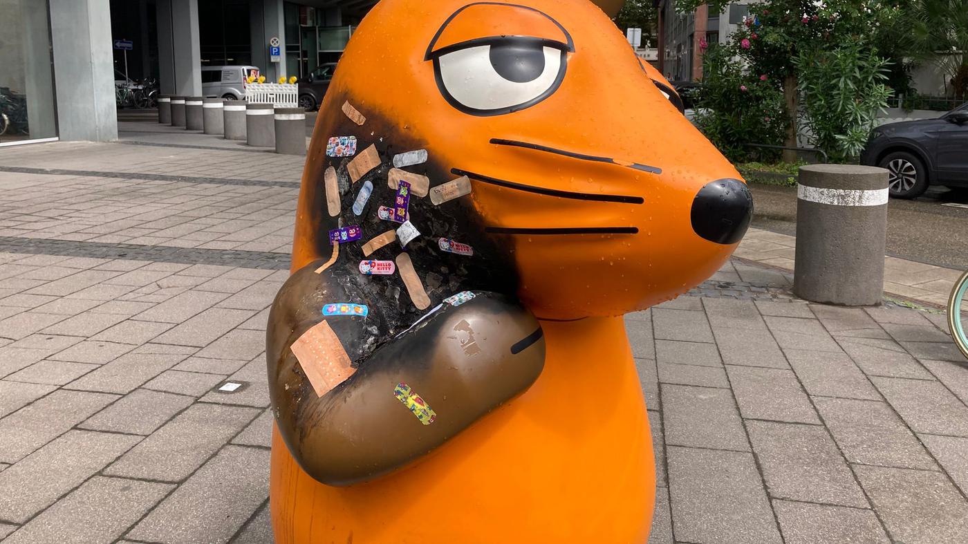 Verkohlte Maus-Figur in Köln wird mit Pflastern versorgt