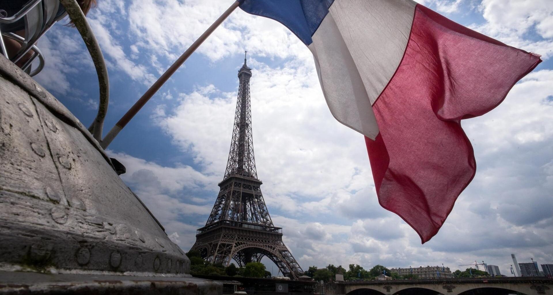 Eine französische Flagge weht vor dem Eiffelturm in Paris.