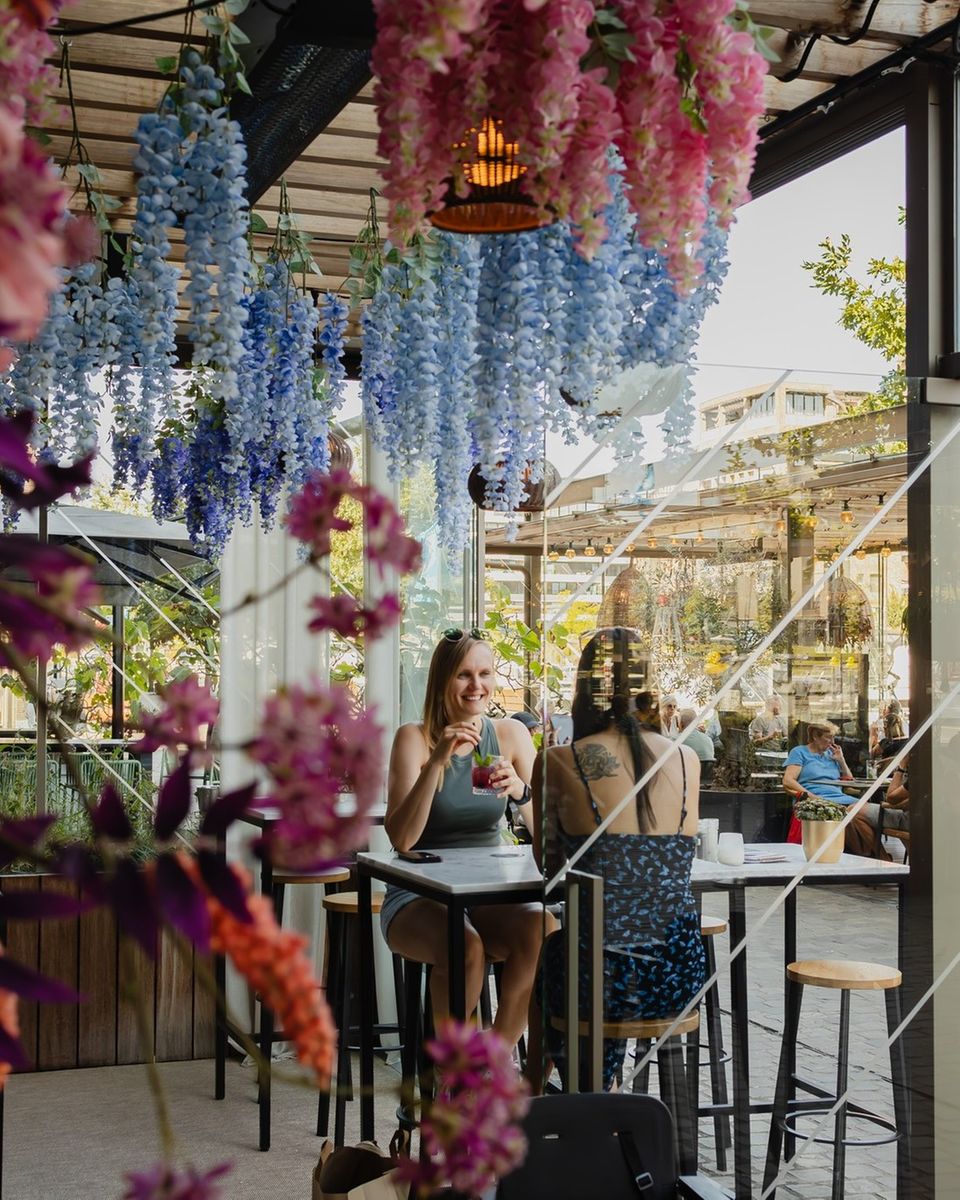 Blumen hängen von einer Decke auf einer Restaurant-Terrasse