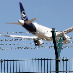 Ein Flugzeug im Landeanflug, im Vordergrund Natodraht. (Quelle: dpa)