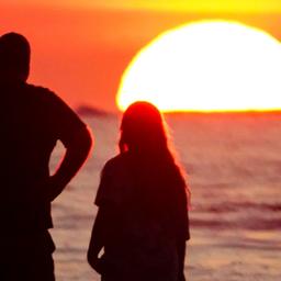 Symbolbild: Zwei personen schauen sich den Sonnenuntergang am Atlantischen Ozean an am 23.06.2025. (QUelle: picture alliance/ZUMA Press Wire/Richard Ellis)