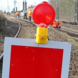Symbolbild:Ein Sperrschild steht auf einem Gleis, im Hintergund wird gebaut.(Quelle:picture alliance/dpa/B.Wüstneck)