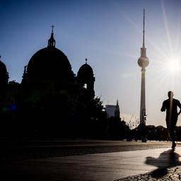 Ein Jogger rennt am frühen Morgen des 30.06.2025 vor dem Berliner Fernsehturm und dem Dom. (Quelle: dpa-Bildfunk/Christoph Soeder)
