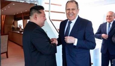 Kim hält mit beiden Händen die rechte Hand von Lawrow und lächelt ihn an, Lawrow blickt derweil in Richtung Kamera und lächelt.