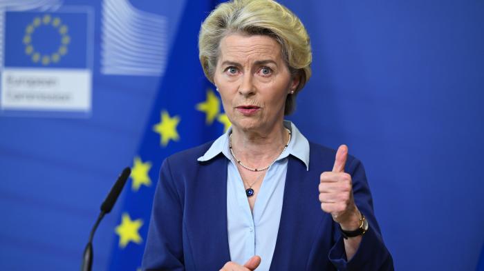 Ursula, von der Leyen vor der EU Fahne, den Daumen gehoben