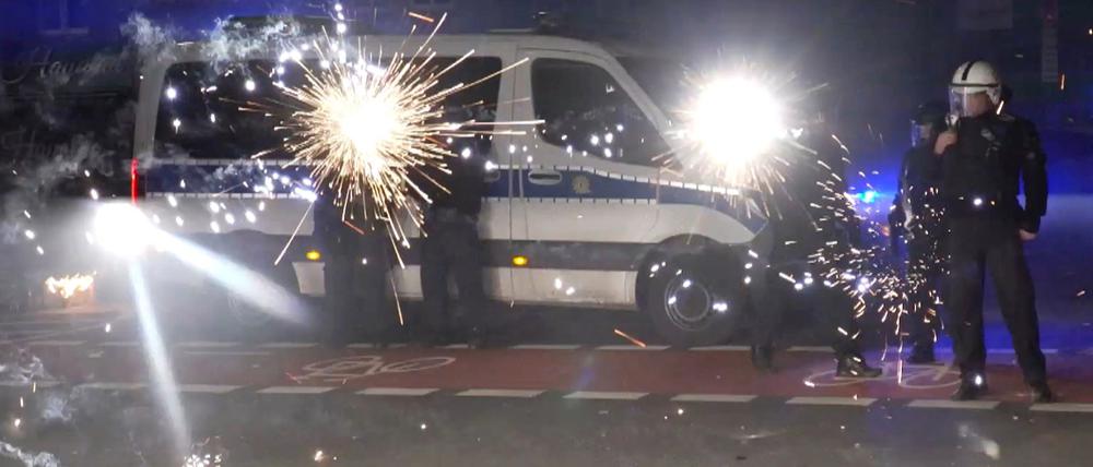 Polizeibeamte an Silvester hinter explodierendem Feuerwerk. (Archivbild)