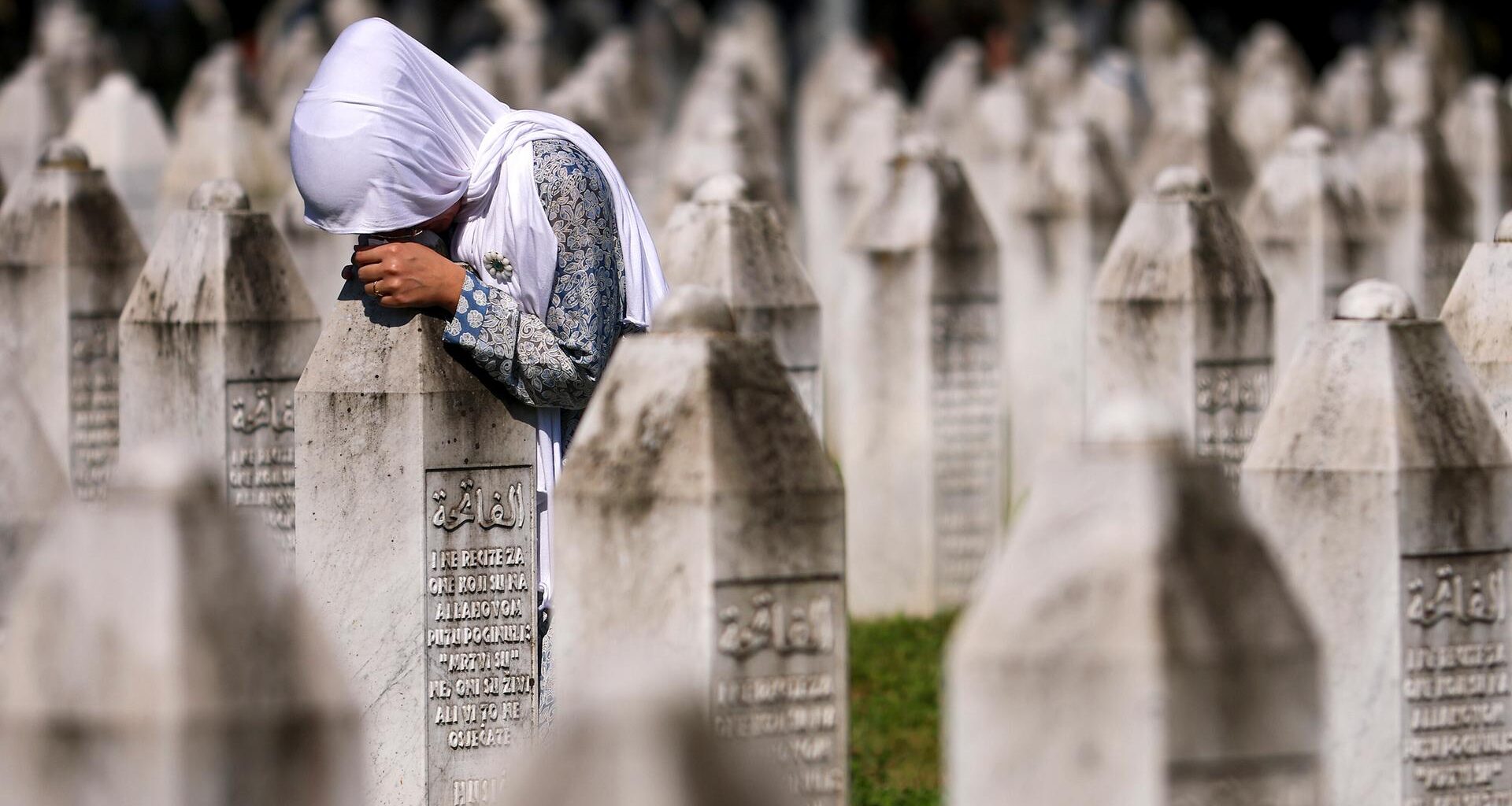Eine muslimische Frau trauert am Grab ihres Verwandten in der Srebrenica-Gedenkstätte in Potocari, Bosnien.