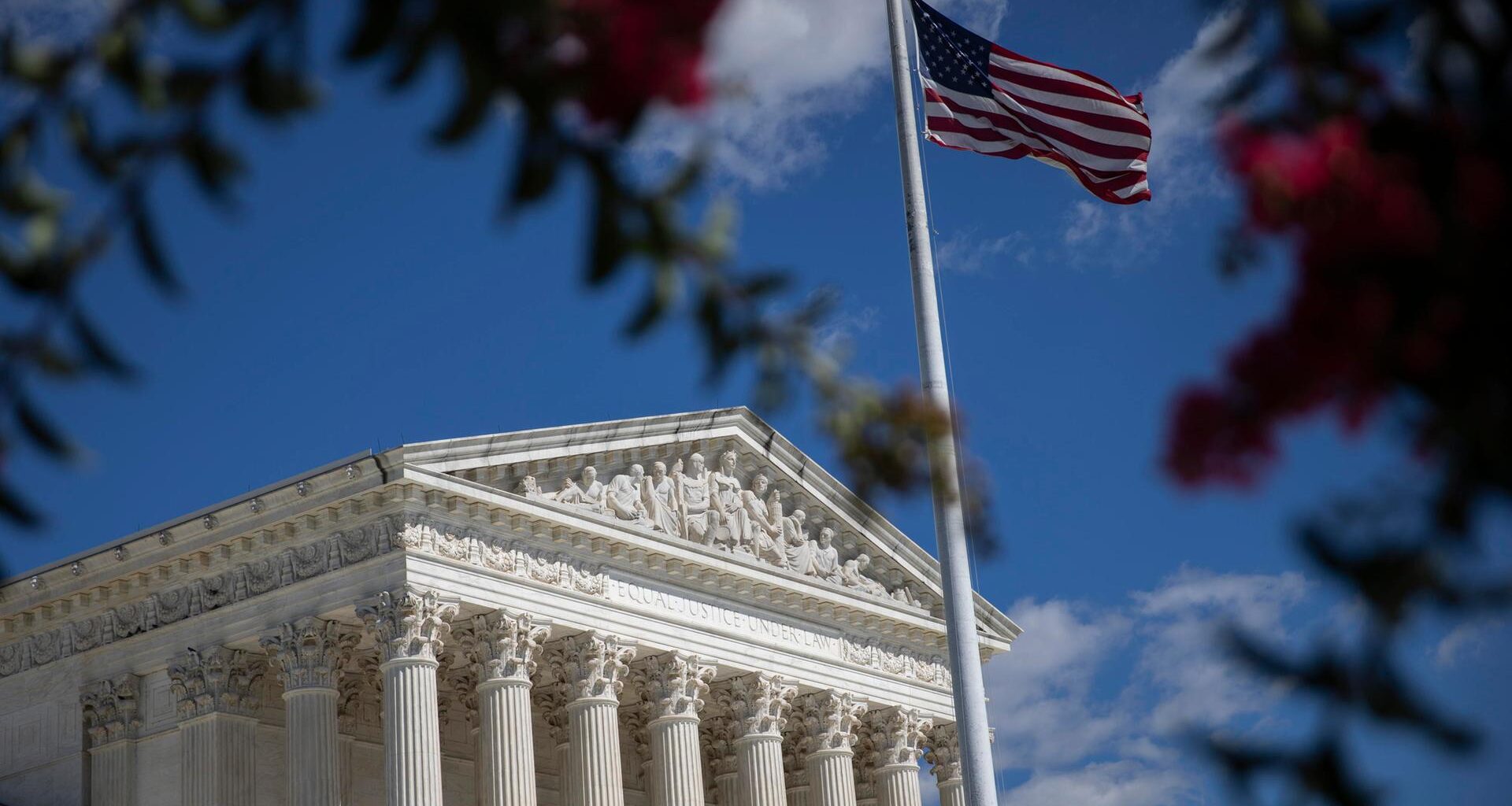 Blick auf den US Supreme Court in Washington, im Vordergrund die amerikanische Flagge