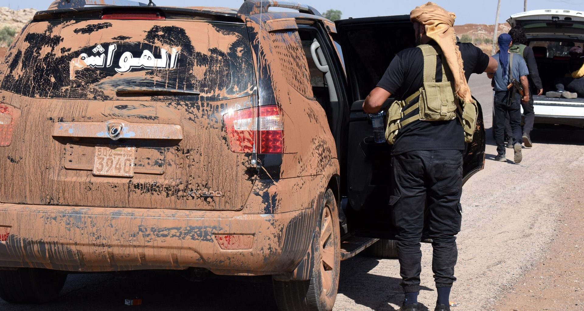 Kämpfer der Beduinen steigen in ein völlig verschmutztes Auto.