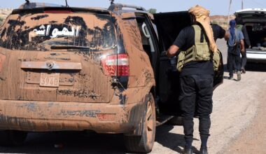 Kämpfer der Beduinen steigen in ein völlig verschmutztes Auto.