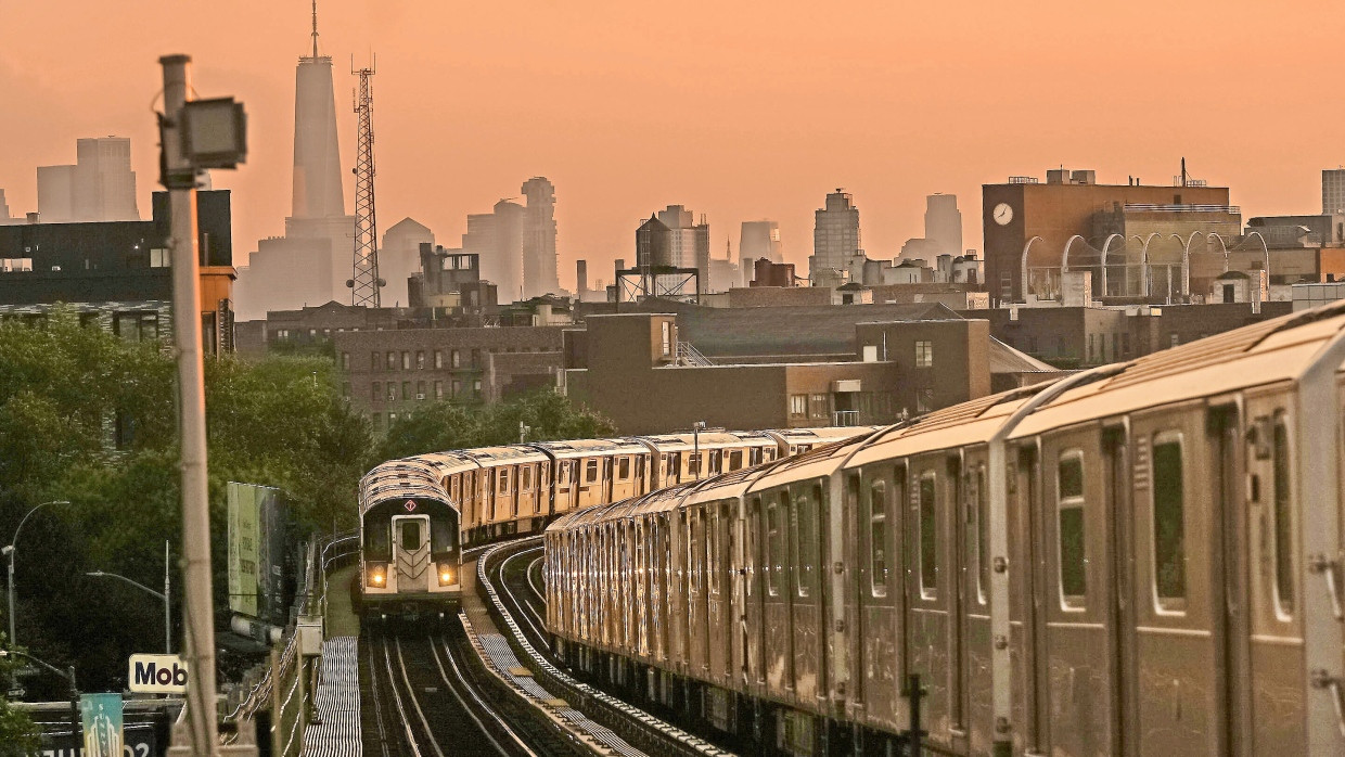 Take the A-Train: New Yorker U-Bahnen, hier oberirdisch fahrend, vor der Skyline der Stadt