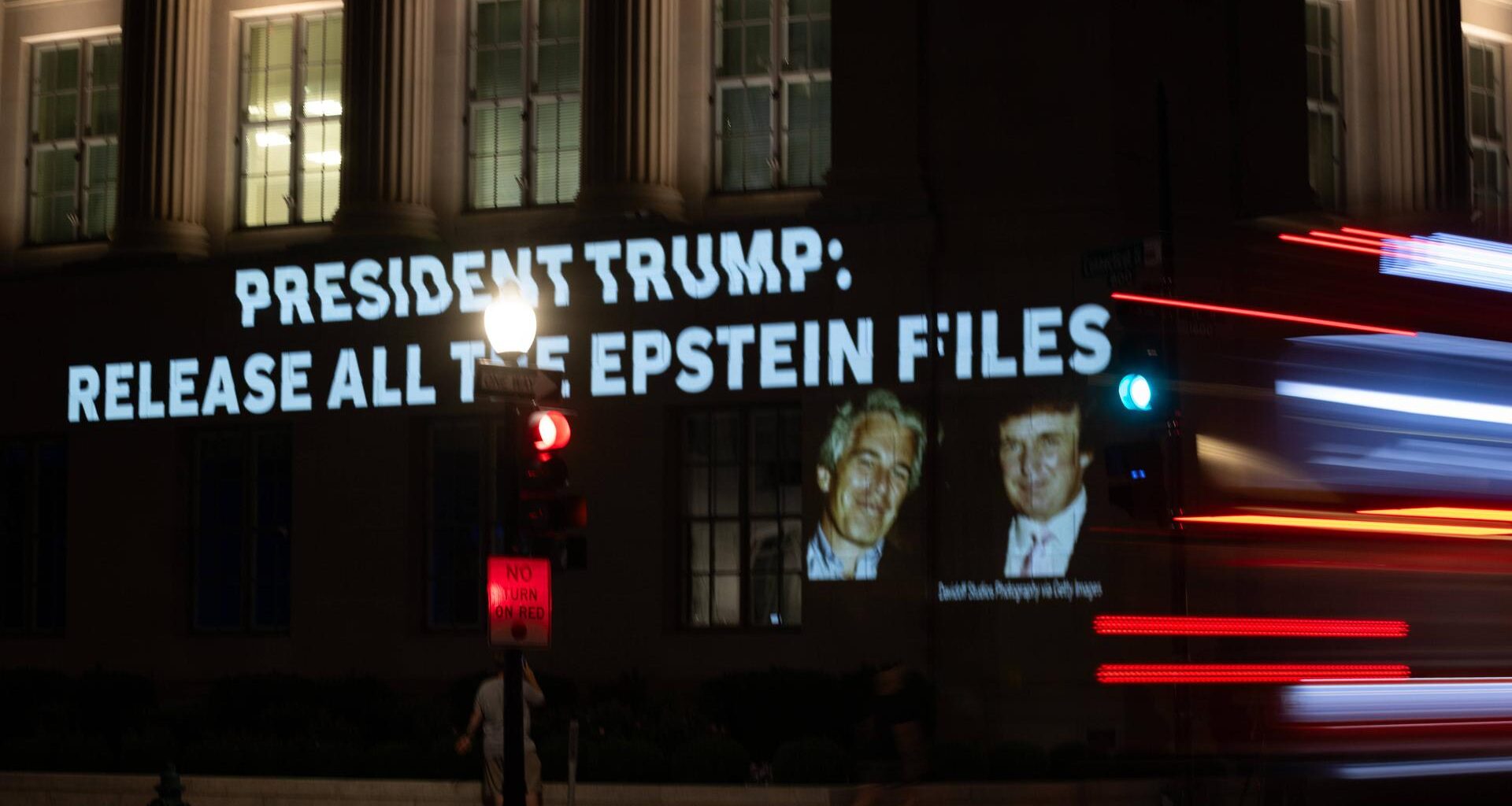 An einer Hauswand ist die Aufschrift "President Trump: Release all the Epstein Files" zu lesen. Daneben ein Foto von Trump und Epstein.