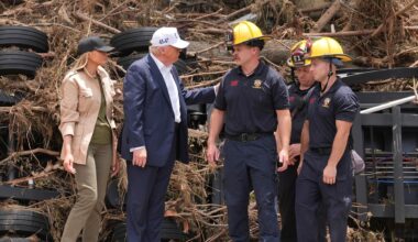 Trump und seine Frau unterhalten sich mit Rettungskräften. Sie stehen nebeneinander.
