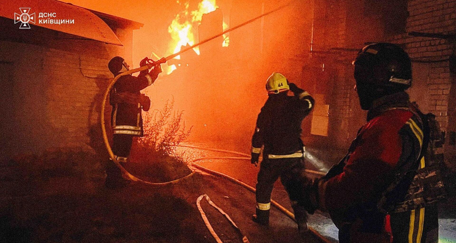 Auf diesem vom ukrainischen Katastrophenschutz zur Verfügung gestellten Foto arbeiten Ersthelfer daran, ein Feuer nach einem russischen Angriff in der Region Kiew zu löschen.