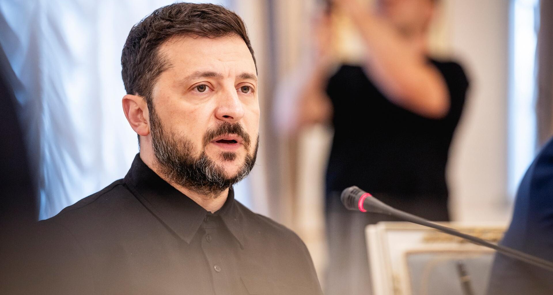 Wolodymyr Selenskyj spricht in ein Mikrofon