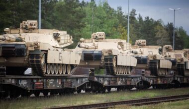 Panzer stehen aufgereit auf einem Bahn-Wagon.