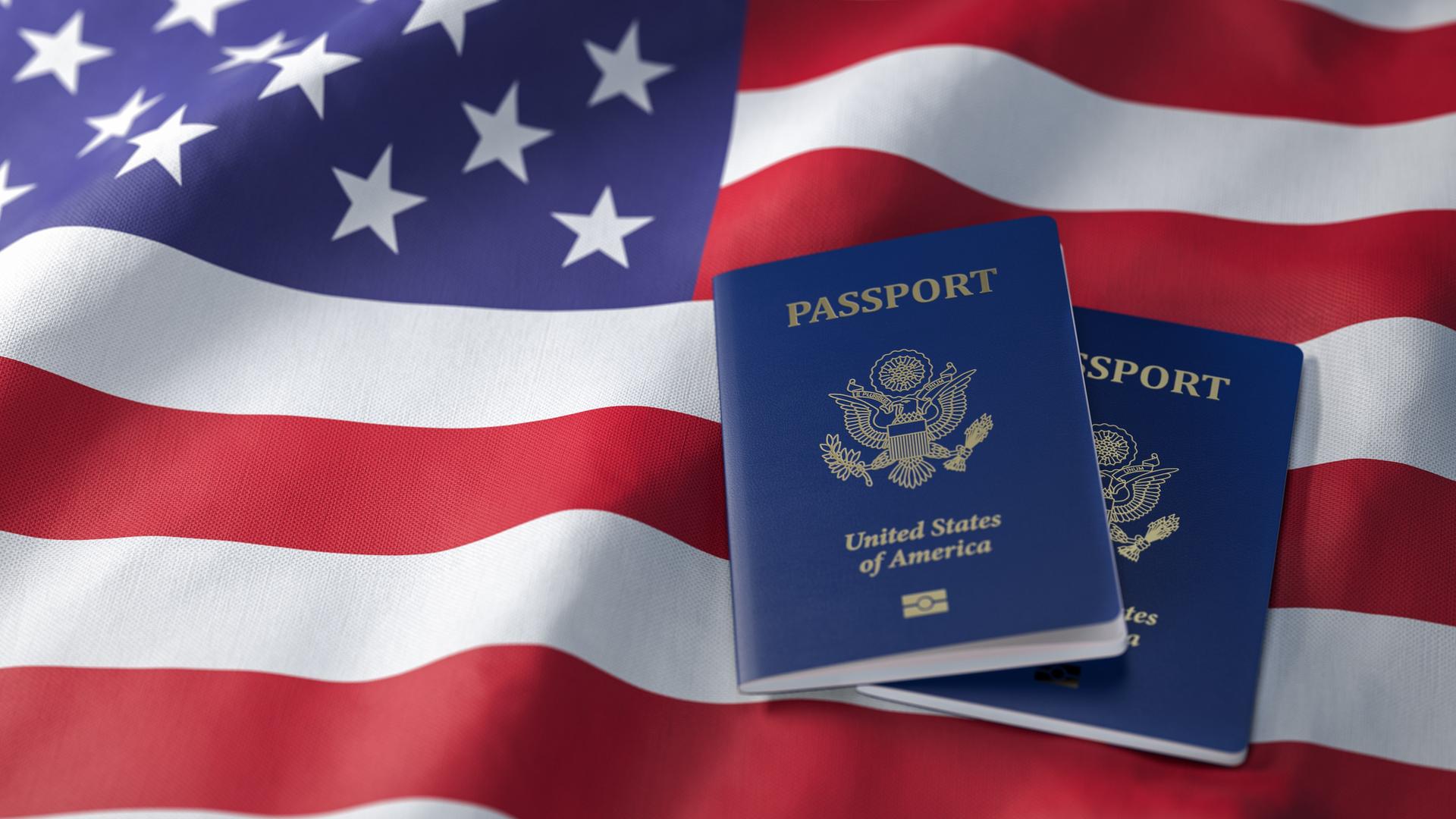 Zwei US-Reisepässe liegen auf einer Flagge der Vereinigten Staaten.