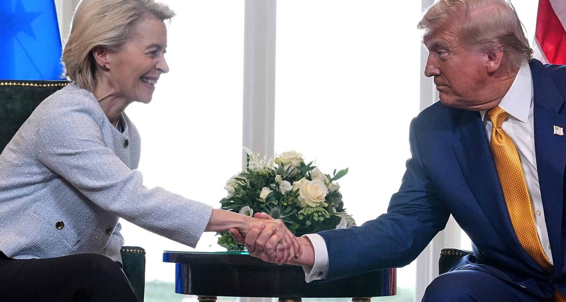 US-Präsident Trump traf die Präsidentin der Europäischen Kommission, von der Leyen, zu Gesprächen in Schottland. Beide schütteln die Hände und lächeln.