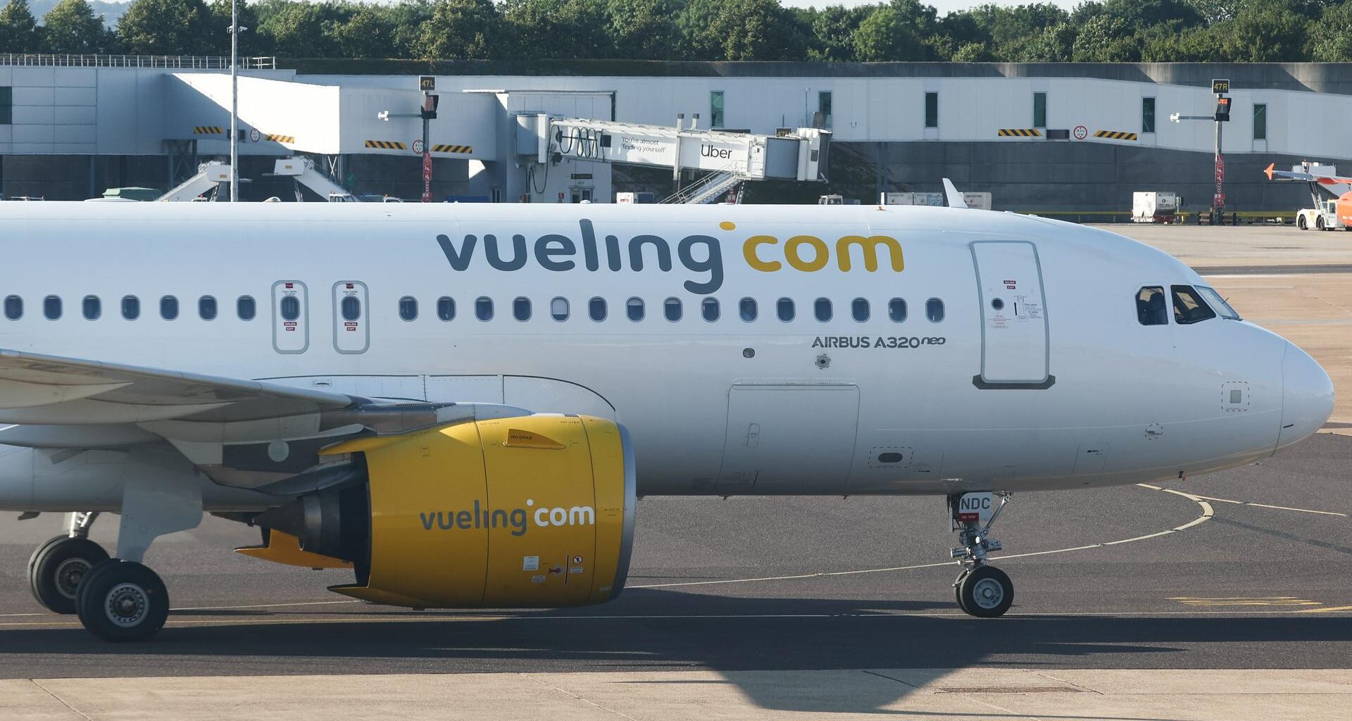Ein Flugzeug von der Fluggesellschaft Vueling. Auf dem Flugzeug steht in großen Buchstaben "Vueling.com".