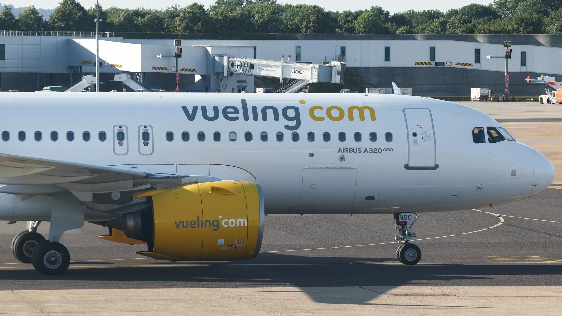 Ein Flugzeug von der Fluggesellschaft Vueling. Auf dem Flugzeug steht in großen Buchstaben "Vueling.com".