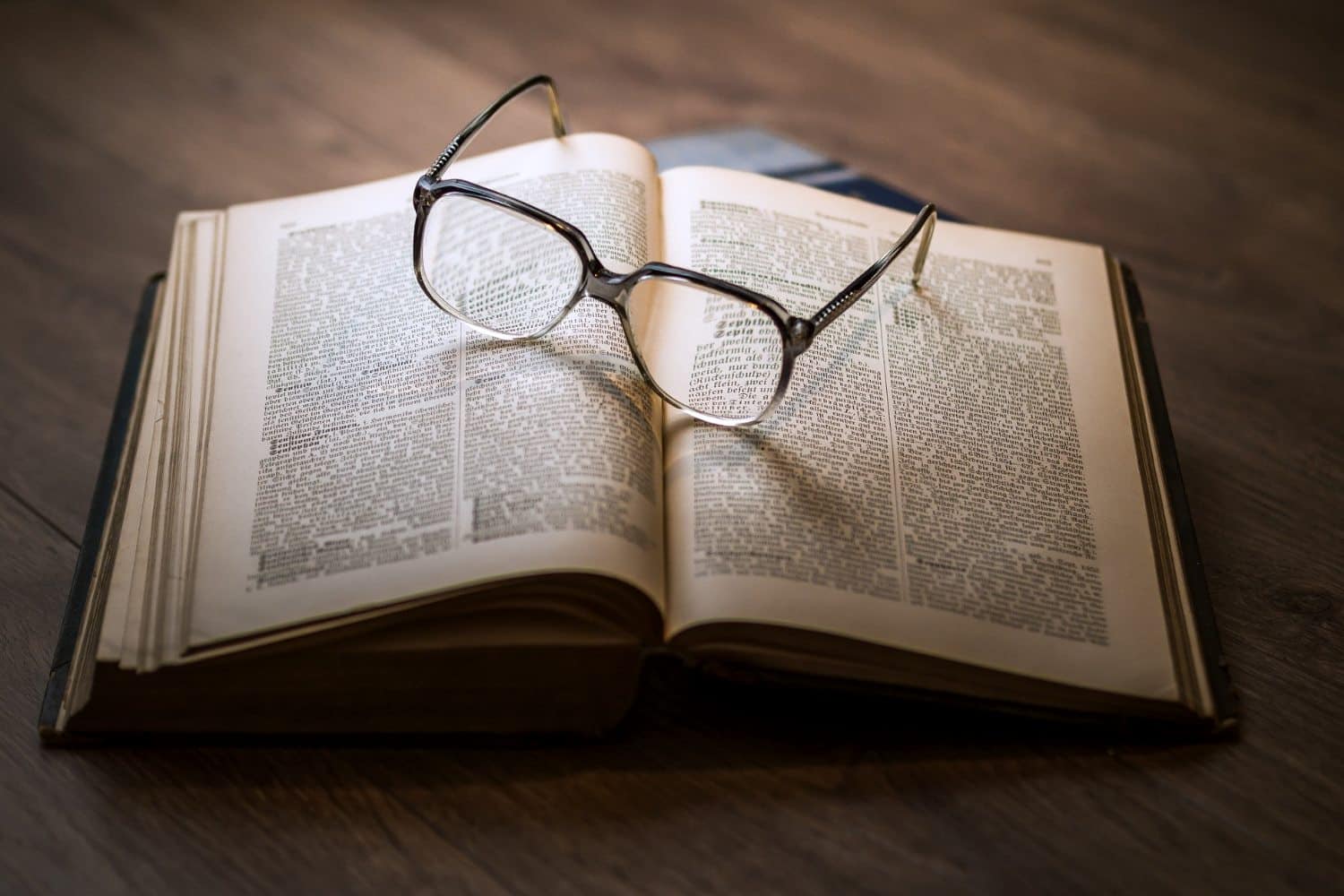 Aufgeschlagenes Buch, auf dem eine Brille liegt