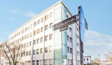 Ein modernes Bürogebäude an der Füllenbachstraße mit einem Straßenschild im Vordergrund.