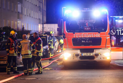 Großeinsatz der Feuerwehr in Leipzig - Feuerwehrleute im Einsatz an der Johannes-R.-Becher-Straße – die Straße war während der Löscharbeiten voll gesperrt.
