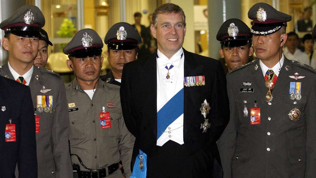 Prinz Andrew (Mitte) posiert mit thailändischen Polizeibeamten auf dem Rückweg nach Großbritannien, nachdem er an den Feierlichkeiten zum 60. Thronjubiläum des thailändischen Königs teilgenommen hat.