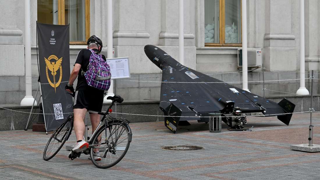 Ein Radfahrer nimmt Notiz von einer in Kiew ausgestellten Drohne russischen Ursprungs.