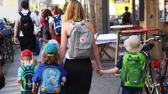 Eine Erzieherin geht in Berlin mit Kindern aus einer Kita auf einem Bürgersteig. (Quelle: dpa/Wolfram Steinberg)