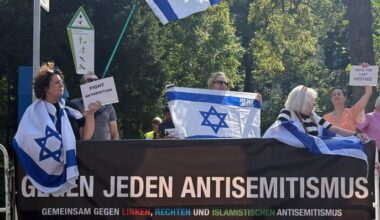 Demonstranten halten israelische Flaggen und protestieren gegen eine umstrittene propalästinensische Solidaritätsveranstaltung der Neuköllner Linke (Quelle: dpa/Paul Zinken).