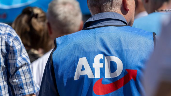 Symbolbild: Mann mit AfD-Weste auf einer Kundgebung. (Quelle: dpa/Hermann)