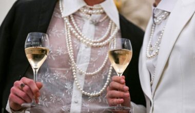 Symbolbild: Wohlhabende Gäste mit Perlenketten halten Champagner in den Händen. (Quelle: dpa/Kalaene)