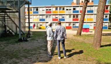 Peter Hermanns und und Baara Mshinish stehen vor einem Gebäude des Containerdorfs im Allende-Viertel und schauen es an.(Quelle:rbb)