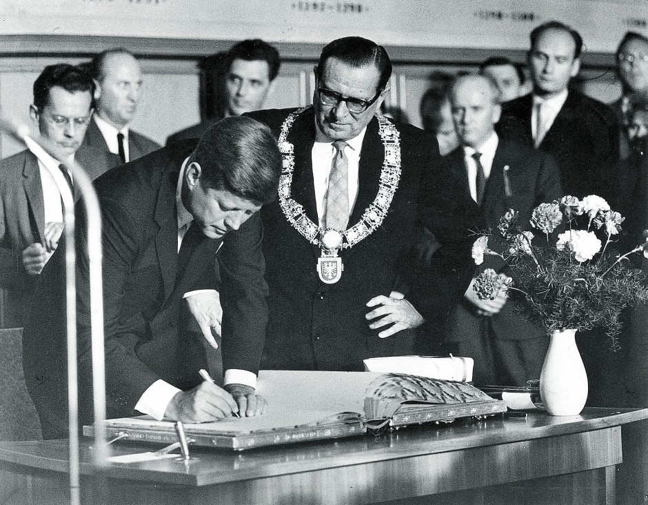 Ganz lässig: John F. Kennedy trägt sich am 25. Juni 1963 in das „Goldene Buch“ ein unter den augen von Oberbürgermeister Werner Bockelmann.