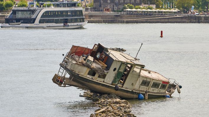 Eine auf einer Untiefe im Rhein festgefahrene Jacht bei Rüdesheim (Quelle: dpa/Thomas Frey).