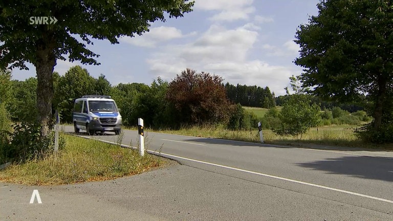 Im Zuge einer Fahndung fährt die Polizei über eine Landstraße im Kreis Kaiserslautern.