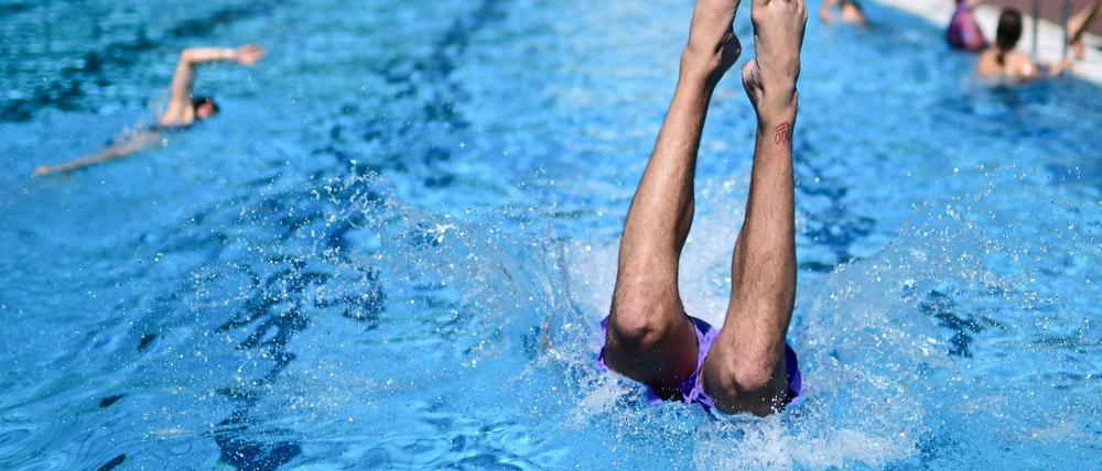in Mann springt im Sommerbad Kreuzberg ins Becken. Angesichts der hohen Temperaturen suchen zunehmend viele Menschen Abkühlung in den Berliner Freibädern.  (Symbolbild)