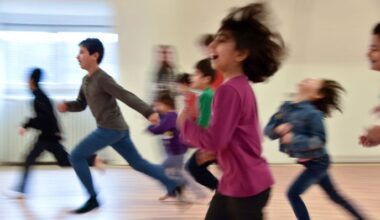 Symbolbild: Flüchtlingskinder rennen in der Erstaufnahmeeinrichtung im Rahmen der Kinderbetreuung durch einen Sportraum. (Quelle: dpa/Zucchi)
