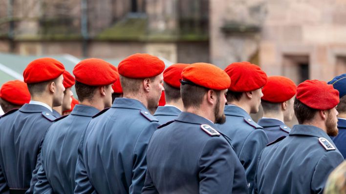 Symbolbild: Heeressoldaten im Dienstanzug mit roten Baretten nehmen an einer feierlichen Geloebniszeremonie bzw. Vereidigung teil. (Quelle: dpa/Fuessmann)