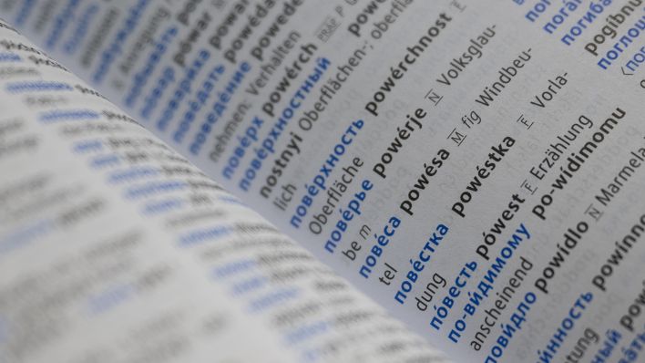 Symbolbild: Wörter in Russisch und Deutsch stehen in einem Wörterbuch. (Quelle: Picture Alliance/Sebastian Gollnow)