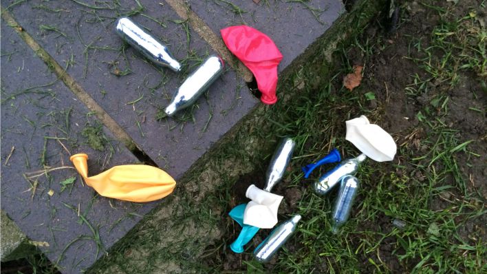 Lachgas-Kartuschen und Luftballons liegen in einem Park im Londoner Stadtteil Shoreditch