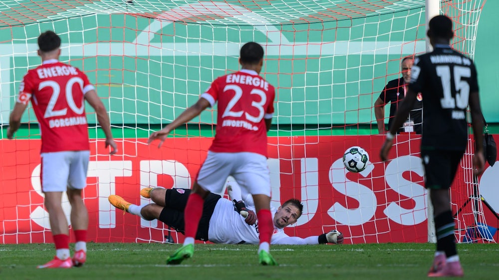 Cottbus-Keeper Alex Sebald fliegt beim Elfmeter in die richtige Ecke.