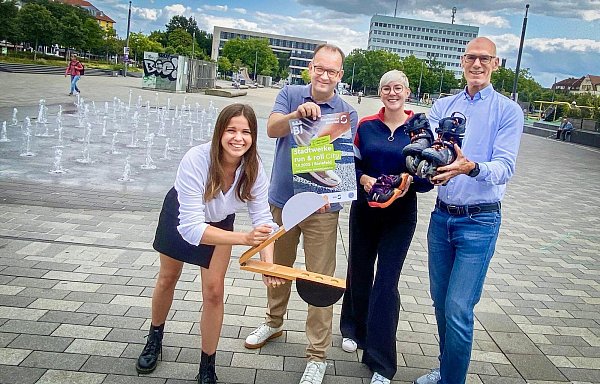 Zwischen Wasserspiel und grünem Würfel präsentieren Karoline Jockheck, Katharina Schilberg und Martin Knabenreich von Bielefeld Marketing, sowie Stadtwerke-Geschäftsführer Rainer Müller den 20. "Run & Roll Day". - © Heimo Stefula