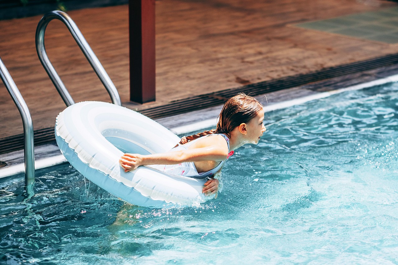 Mädchen mit Schwimmreifen im Pool