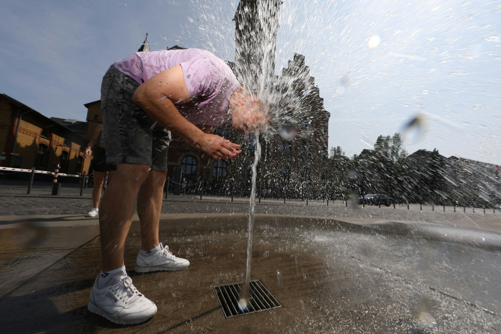 13.06.2025, Köln: Eine kleine Abkühlung für Edgar und Gulia am Brunnen am Hafenamt. Wetter, Feature: Köln erlebt den ersten Hitzetag des Jahres mit Temperaturen von mehr als 30°C. Foto: Arton Krasniqi